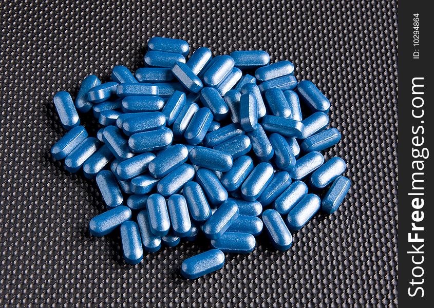 Oval blue vitamins on the black table. Oval blue vitamins on the black table