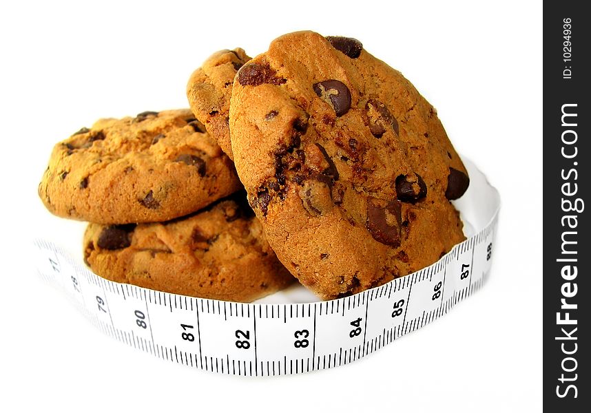 Chocolate cookies wrapped in a measuring tape showing temptation vs. diet. Chocolate cookies wrapped in a measuring tape showing temptation vs. diet