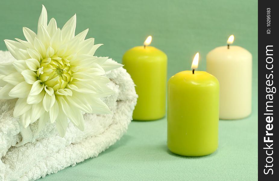 Spa concept. White towel, candles and flower.