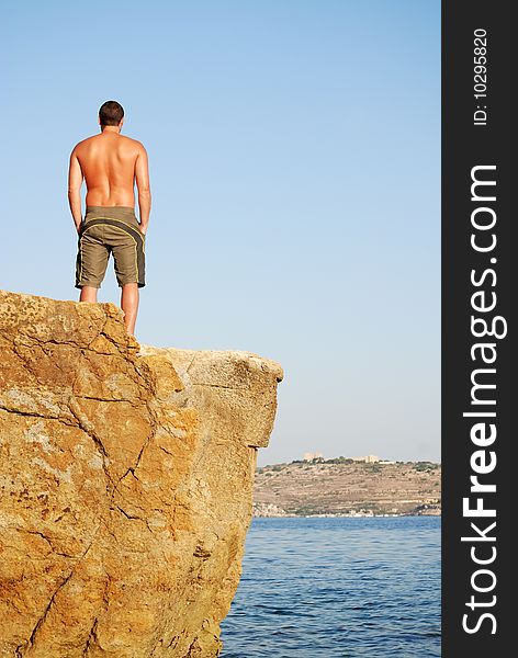 Man standing on top of cliff. Man standing on top of cliff