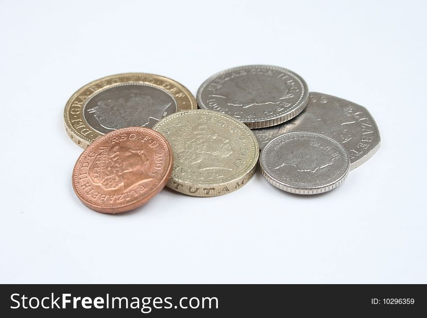 Scattered united kingdom coins on a white background