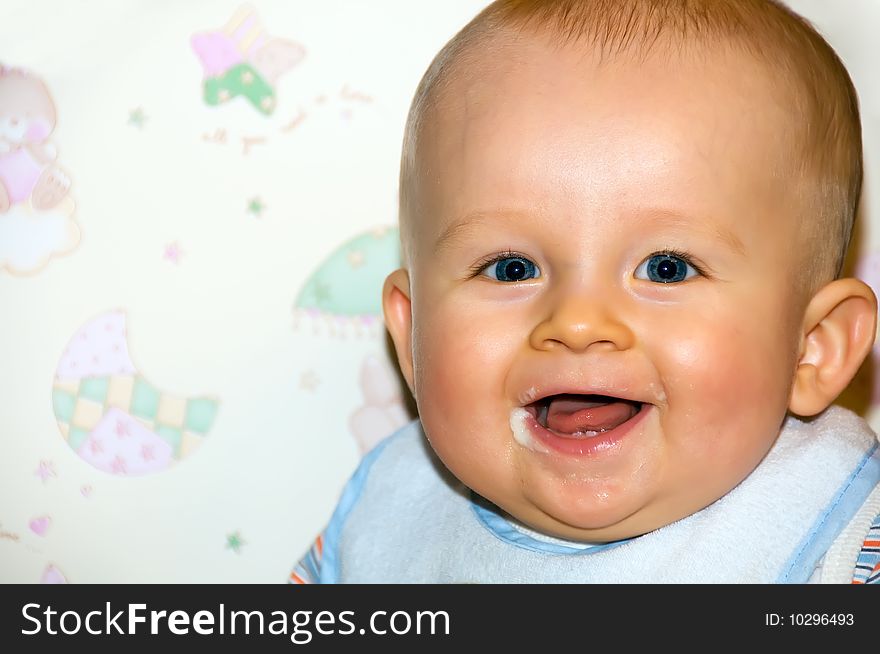 Portrait of happy baby after feeding. Baby is smiling and sitting on baby's chair. Baby's face is messy. Portrait of happy baby after feeding. Baby is smiling and sitting on baby's chair. Baby's face is messy.