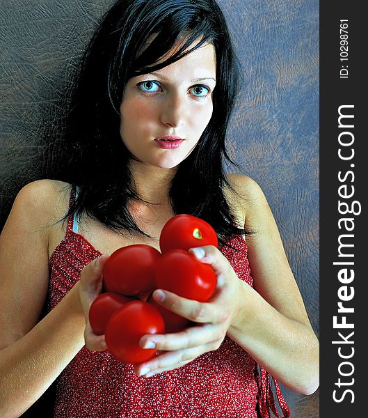 Closeup portrait of a beautiful girl holding red tomatoes.