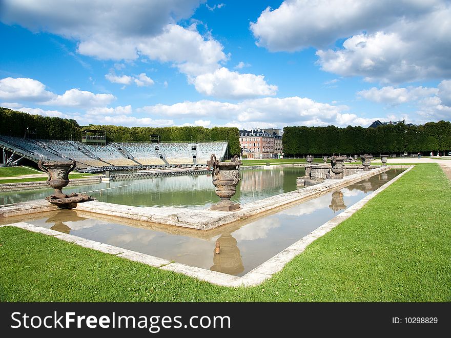 Classic fountain in paris royal park with water reflection