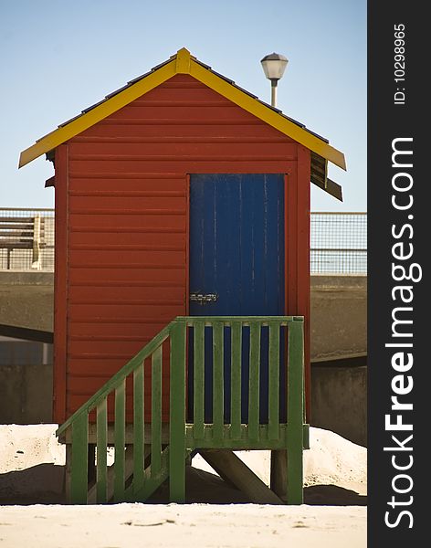 A bright colored beach hut standing on a beach. A bright colored beach hut standing on a beach