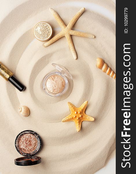 Starfishes, eyeshadow and glitter on the sand. Starfishes, eyeshadow and glitter on the sand