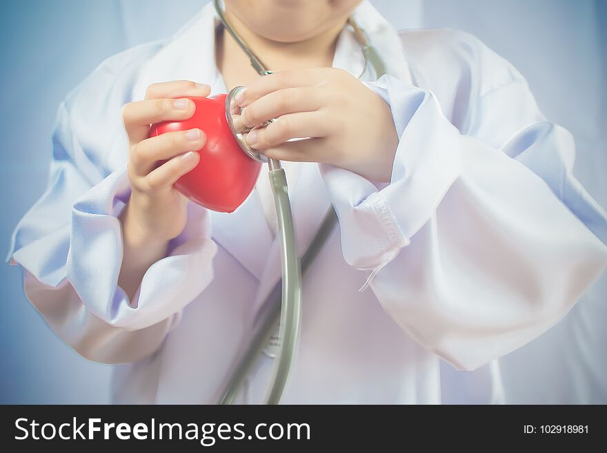 Asian girl playing as a doctor care healthy heart.