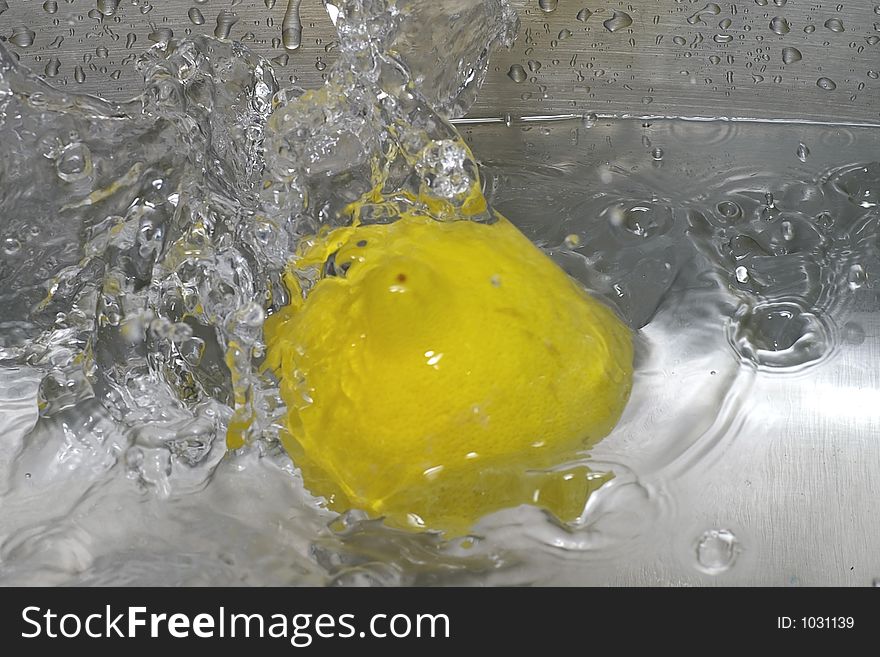 Closeup of a lemon spashing into a pool of water. Closeup of a lemon spashing into a pool of water