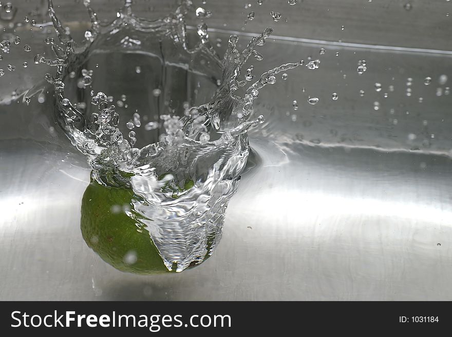 Closeup of a lime spashing into a pool of water. Closeup of a lime spashing into a pool of water
