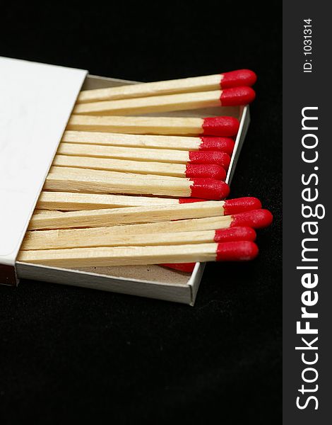 Closeup of Red Tipped wooden match sticks in a match box