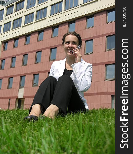 BUSINESSWOMAN AND PHONE IN GRASS