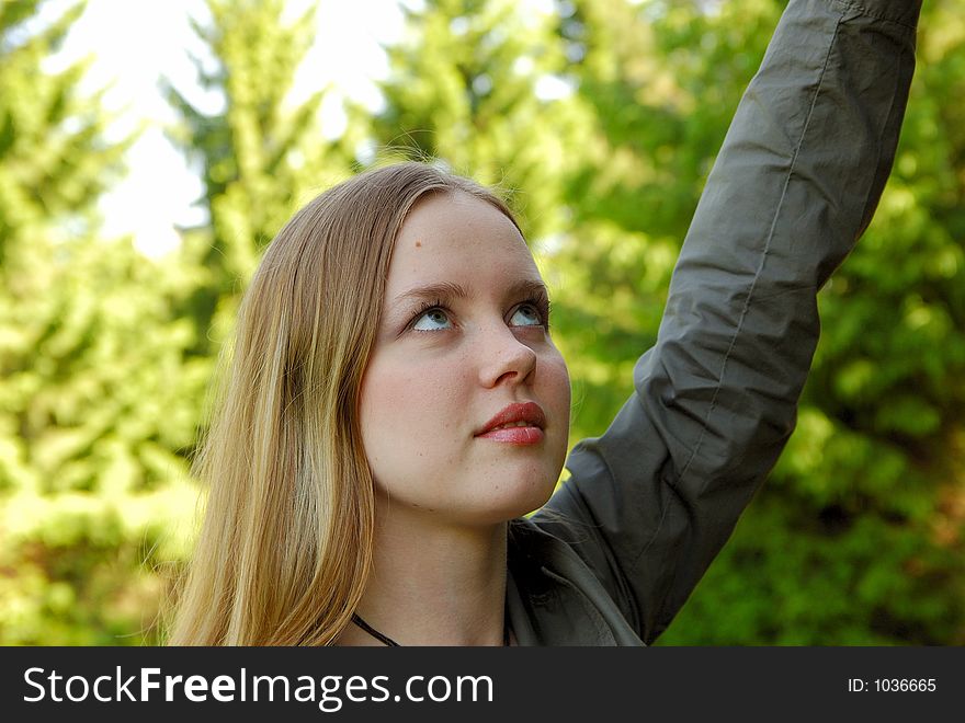 Beautiful girl in park with hand up