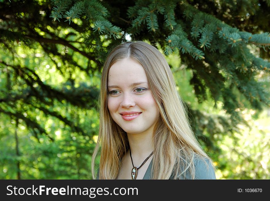 Beautiful girl in park at pines background