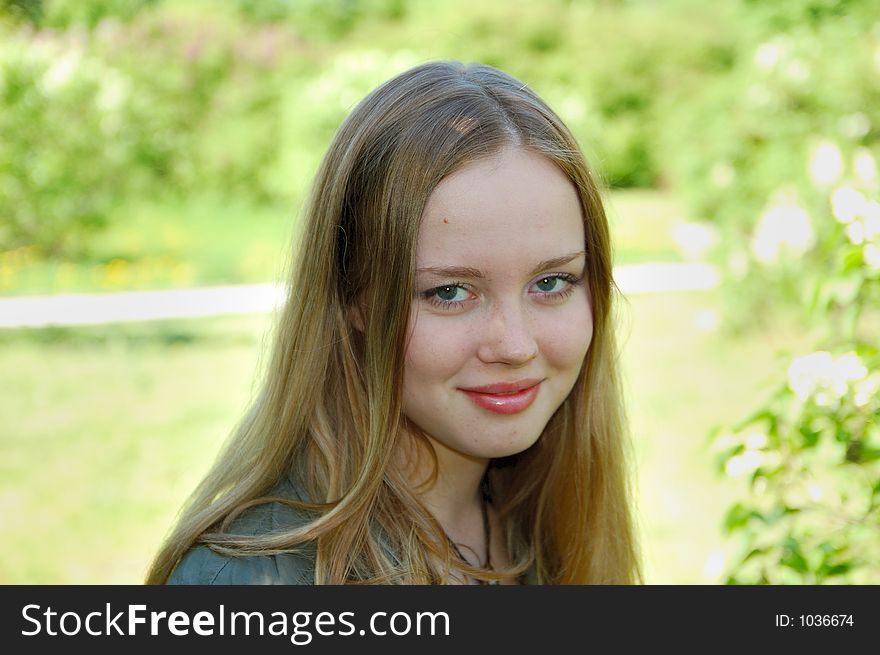 Beautiful girl in park at green background