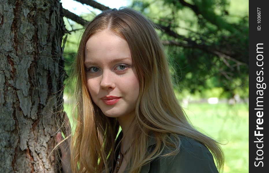 Beautiful girl in park at pines background