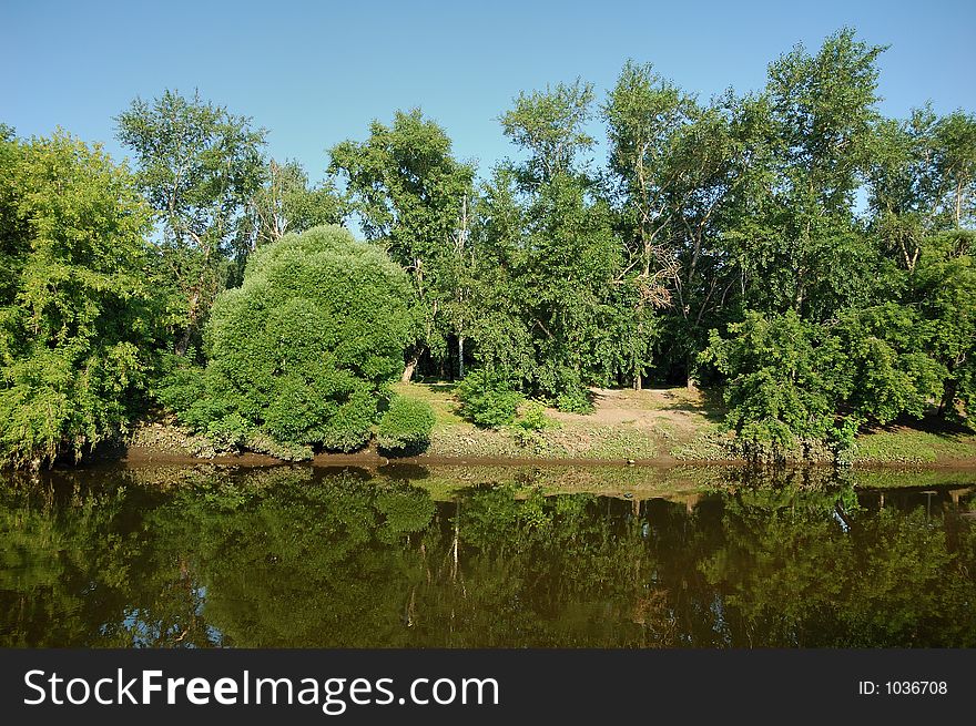 Peaceful scenic view of river and landscape in summer morning