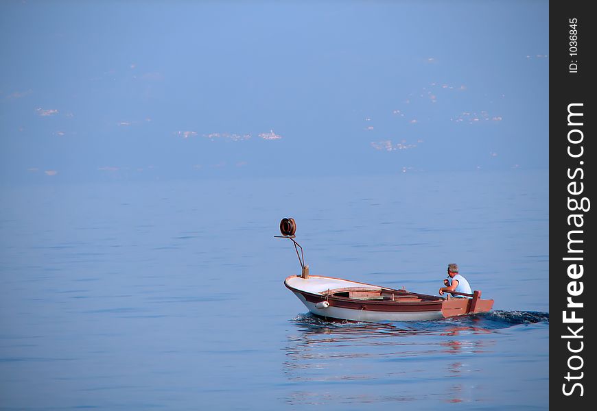 Fisherman in a small boat on a sea