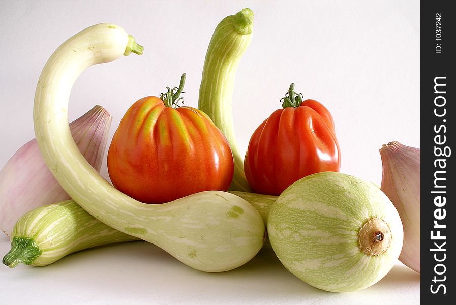 A selection of trumpet zucchini,beef tomato and sweet onion. A selection of trumpet zucchini,beef tomato and sweet onion