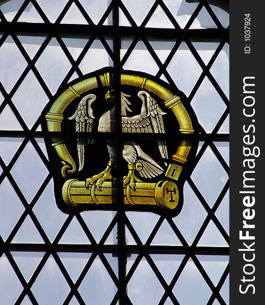 Stained glass eagle insignia in Tudor lattice lead window. Stained glass eagle insignia in Tudor lattice lead window