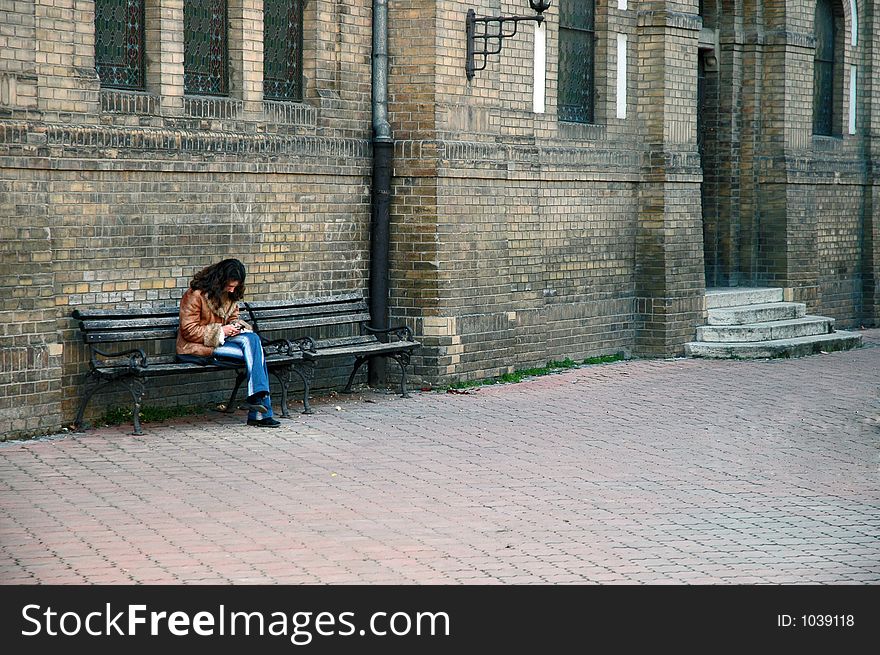 Woman sitting on a bench using mobile phone. Woman sitting on a bench using mobile phone
