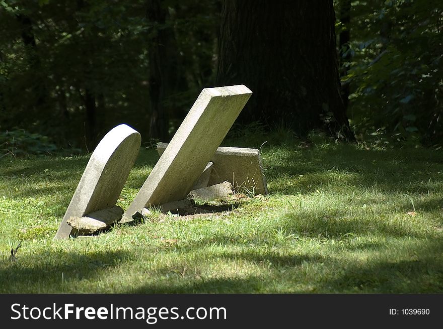 2 very old gravestones in a country cemetery lean at an extreme angle from age. 2 very old gravestones in a country cemetery lean at an extreme angle from age