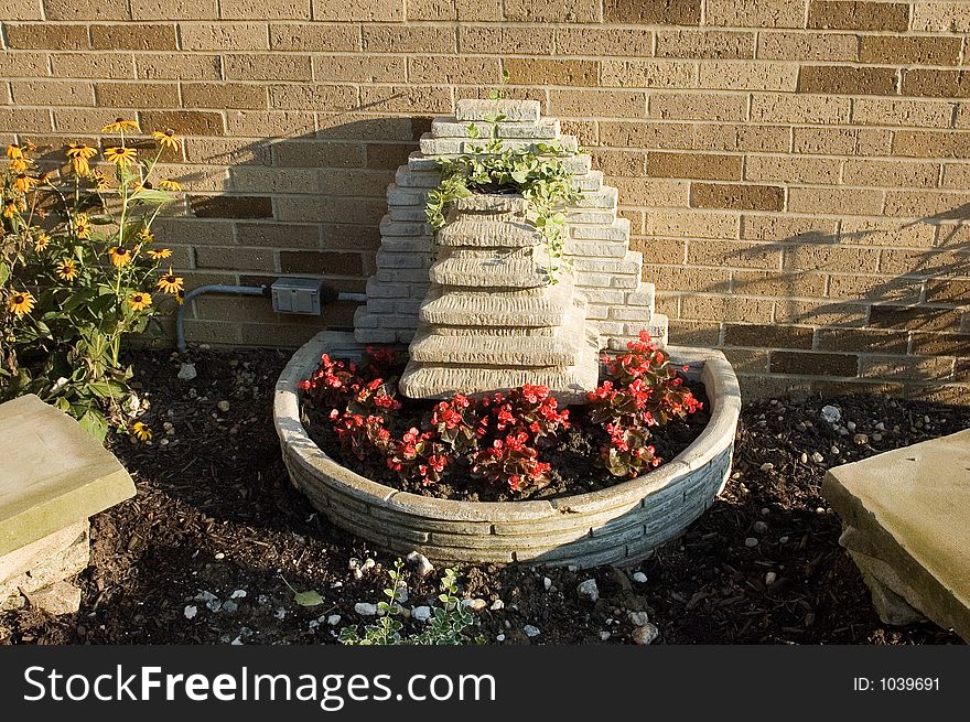 A water fountain turned into a planter. Bottom contains begonias and top has Vinca Vines to represent the water flowing down. A water fountain turned into a planter. Bottom contains begonias and top has Vinca Vines to represent the water flowing down