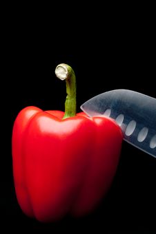 A Red Pepper Being Sliced On A Dark Background Royalty Free Stock Photos