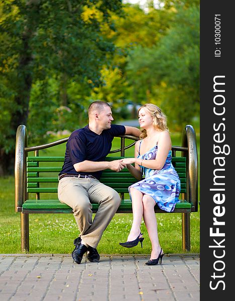 Caucasian couple in love sitting at a bench