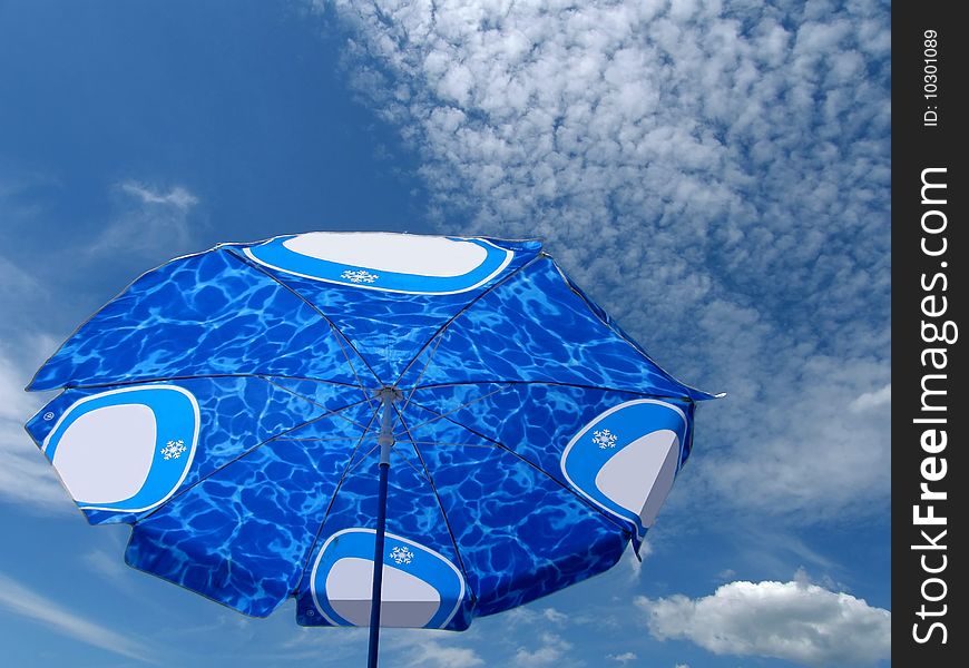 Blue sky and beach umbrella on beach (compare umbrella and sky). Blue sky and beach umbrella on beach (compare umbrella and sky)