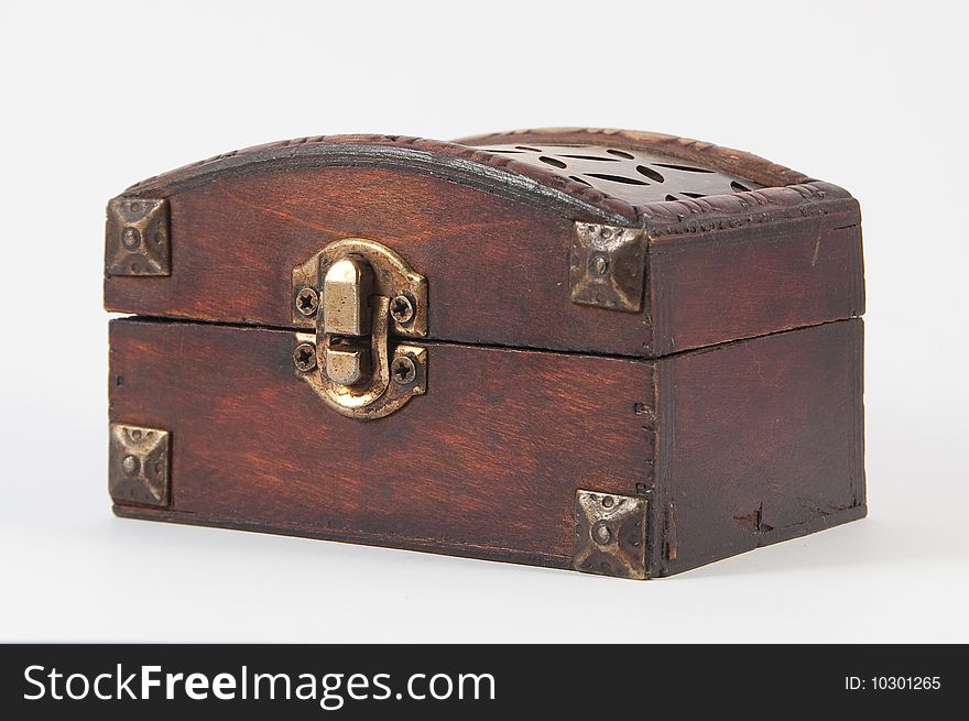 Wooden chest with metal lock and some carvings at the top.