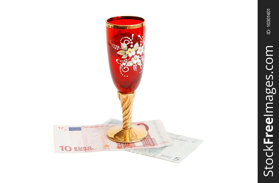 Beautiful red wine glass with golden stem on euro bills isolated. Beautiful red wine glass with golden stem on euro bills isolated