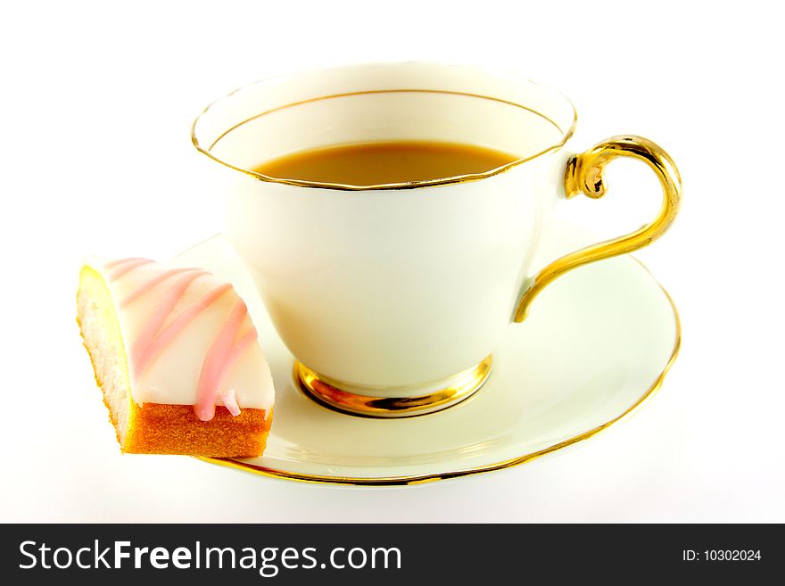 Tea in a cup and saucer with pink slice of cake on a white background. Tea in a cup and saucer with pink slice of cake on a white background