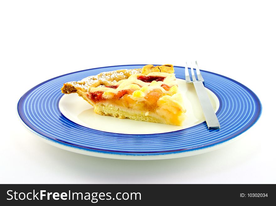 Slice of strawberry and apple pie on a blue plate with a small fork on a white background. Slice of strawberry and apple pie on a blue plate with a small fork on a white background