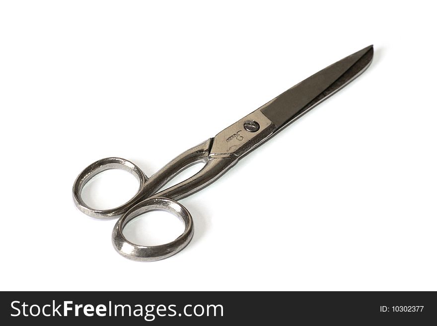 Pair of scissors lying on a white background