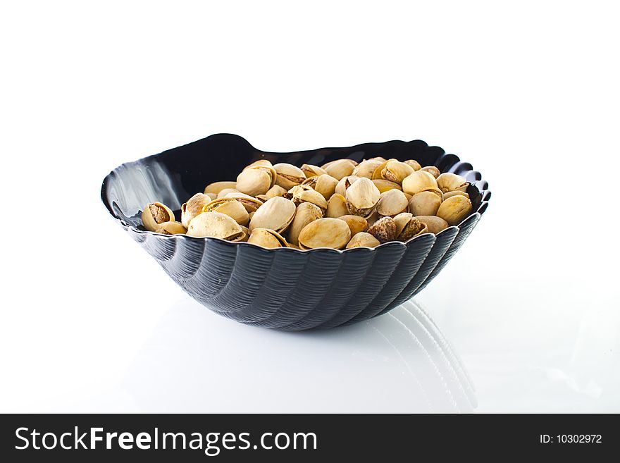 Bowl of pistachios on white backround