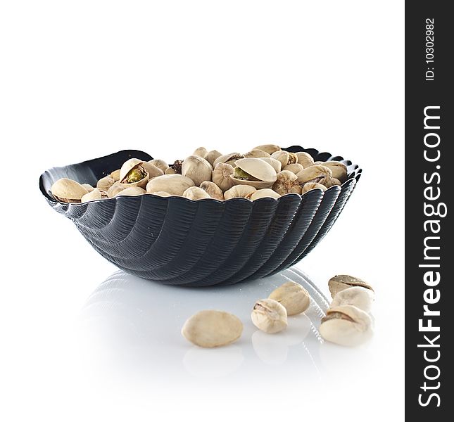 Bowl of pistachios on white backround