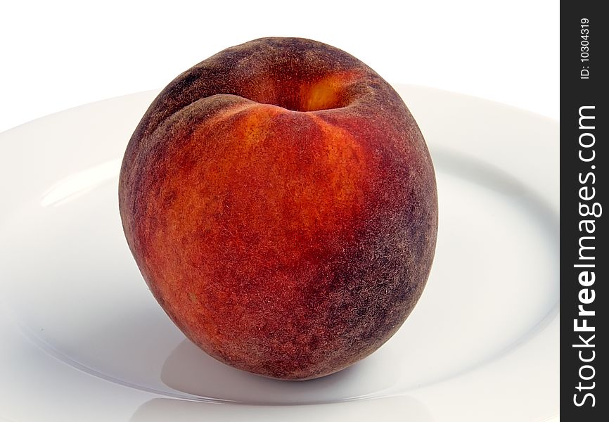 Ripe peach on a plate on a white background