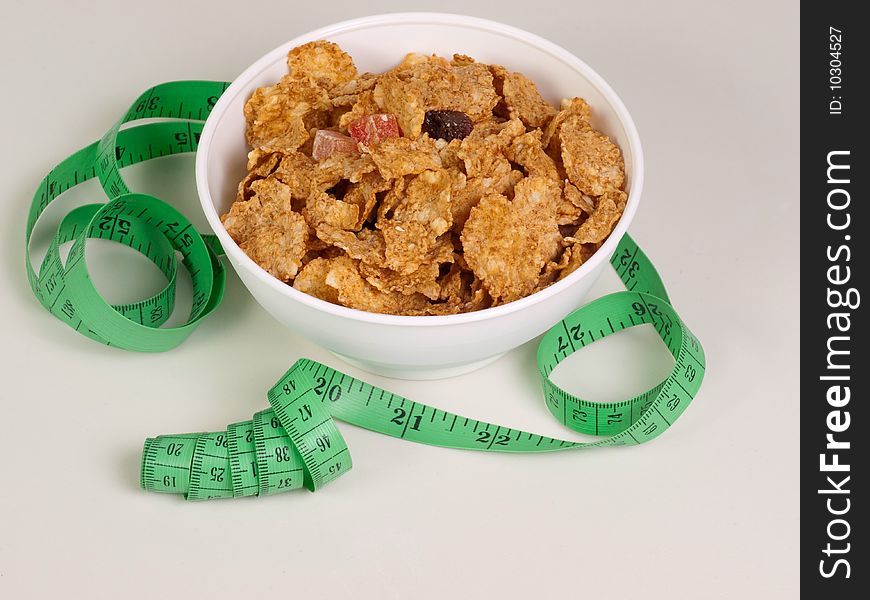 Measurement tape wrapped around dish with flakes/Concept for health, diet