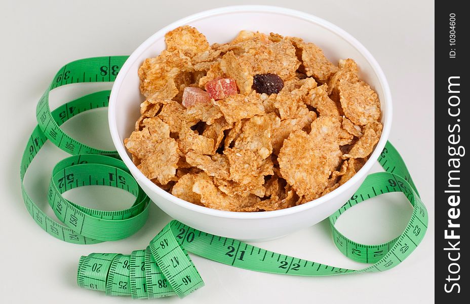 Measurement tape wrapped around dish with flakes/Concept for health, diet