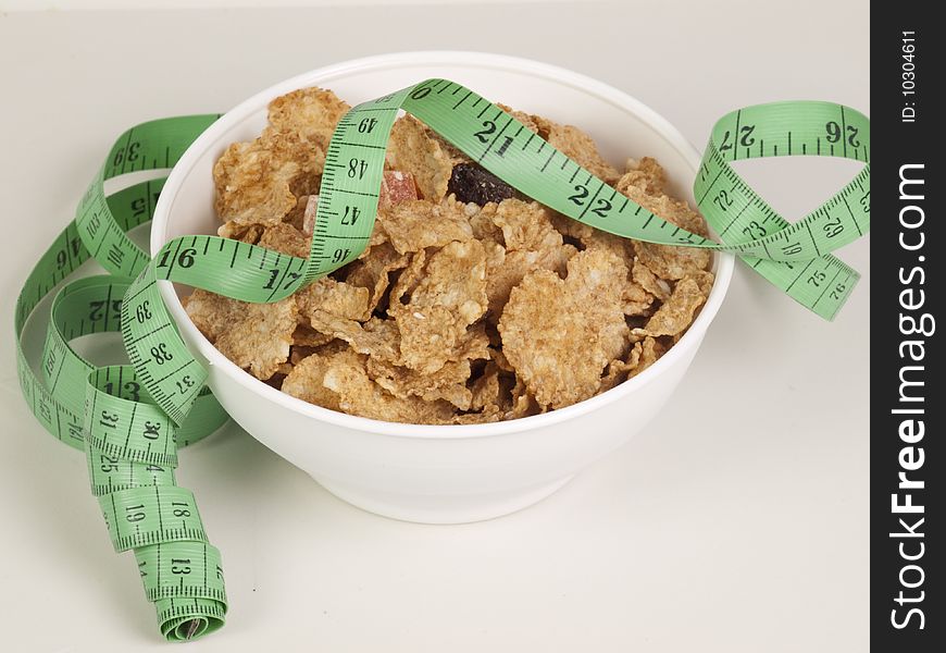 Measurement tape wrapped around dish with flakes/Concept for health, diet