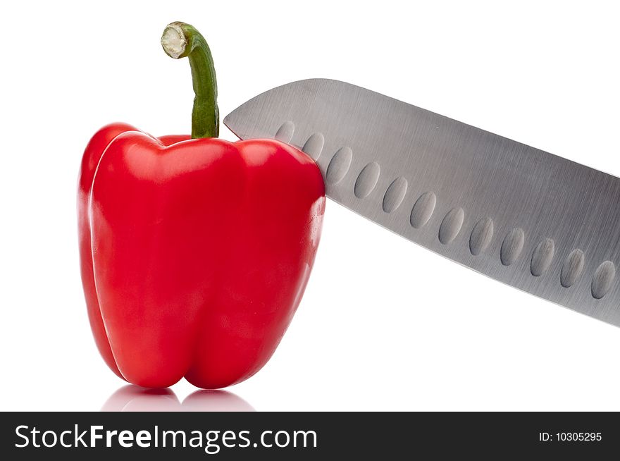 A red pepper being sliced on white