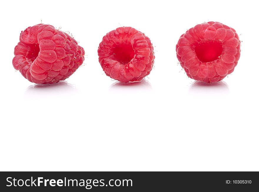A horizontal image of three fresh raspberries on white