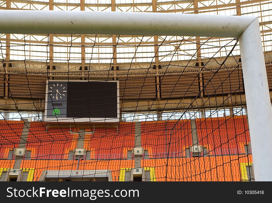 Corner of the net of the football field on the stadium with rows of empty seats in the background