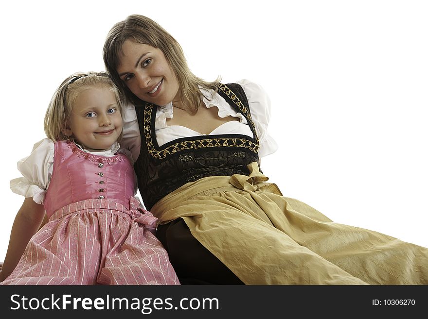 Bavarian Mother and Daughter are sitting on the floor dressed with typical Oktoberfest Dirndl. Bavarian Mother and Daughter are sitting on the floor dressed with typical Oktoberfest Dirndl