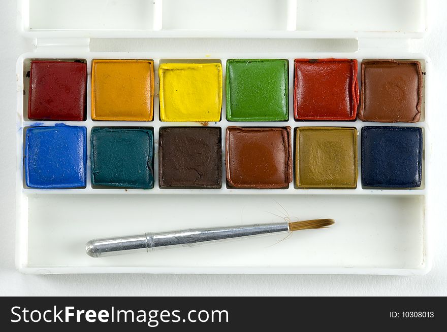 Miniature set of watercolor paints and brush. Miniature set of watercolor paints and brush.