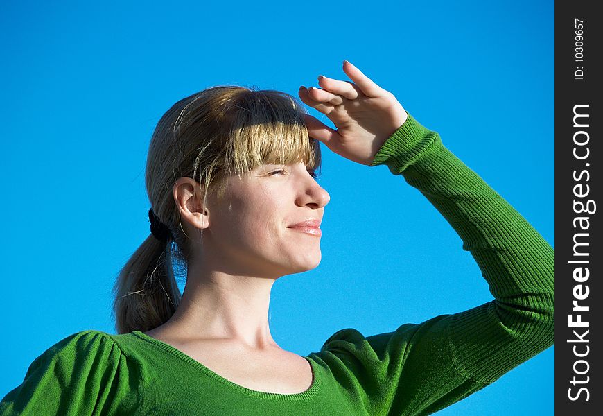 Portrait of the young woman posing on a background of the dark blue sky. Portrait of the young woman posing on a background of the dark blue sky