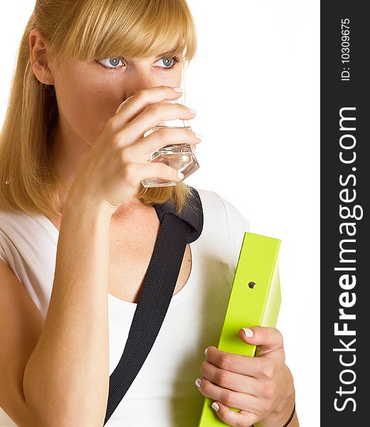 The young student drinks water from a glass on a white background. The young student drinks water from a glass on a white background