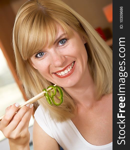 The young woman eats green salad. The young woman eats green salad