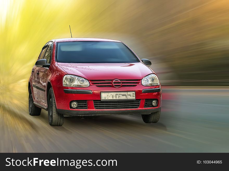 Red Volkswagen car on a blurred background in motion. Red Volkswagen car on a blurred background in motion.