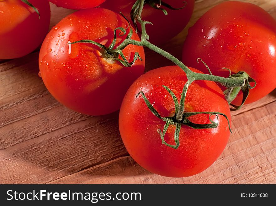 Close up shot of freshly picked tomatoes on wooden table